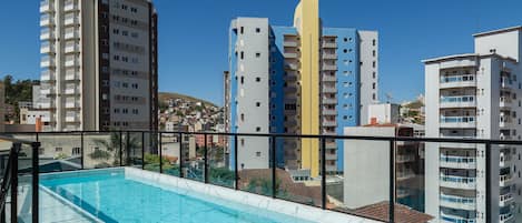 Una piscina en la azotea con vistas despejadas de los edificios altos circundantes.
