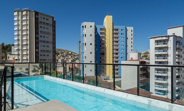 Una piscina en la azotea con vistas despejadas de los edificios altos circundantes.