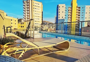 A rooftop pool area with lounge chairs and a view of surrounding buildings. - Lovely and Elegant in Pocos de Caldas Pgo0205 (Poços de Caldas)