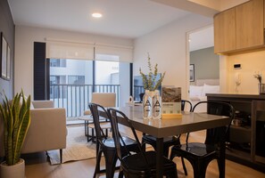 A modern dining area with a table, chairs, and a potted plant.