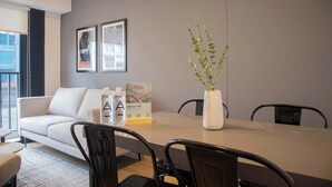 A modern meeting room with a white table, black chairs, a white vase with green plants, and framed pictures on the wall. - w Striking 1BR Duplex in Miraflores (Lima)