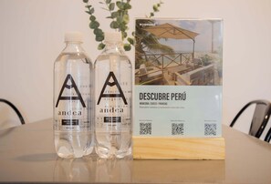 Two bottles of 'Aandea' water and a brochure for 'Descubre Perú' on a table.
