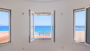 A room with three windows offering a view of the sea. - Beachfront Ela Luxury Stay With Jacuzzi Views (Kithira)