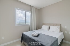 A bedroom with a bed, a window, and a view of the city. - 3 Suite ap 600 m From the Beach Porto Belo Pdp904 (Porto Belo)