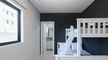 Ein Schlafzimmer mit Etagenbett, einem Fenster und Blick auf ein Gebäude.