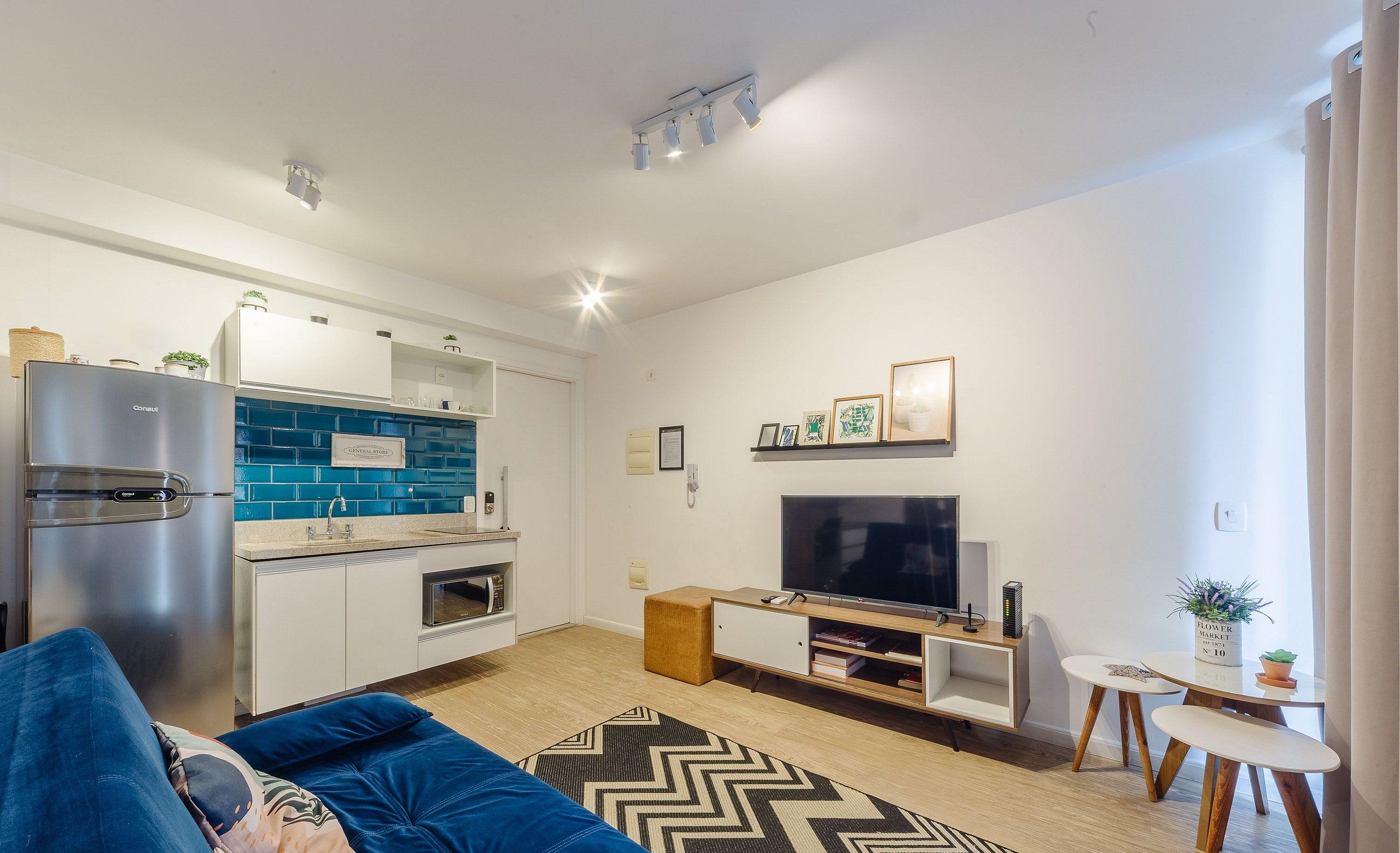 A modern living room with a sofa, a TV, and a small dining table.