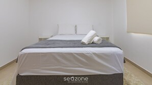 A neatly made bed with white and gray bedding, a rolled white towel, and a small bedside table. - 2-bedr Apt With Pool, 850m From the Beach Pdm005 (Porto Seguro)