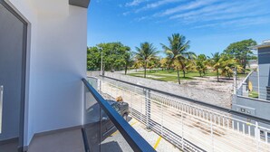 A balcony with a view of a sandy beach and palm trees. - 2-bedr Apt With Pool, 850m From the Beach Pdm005 (Porto Seguro)