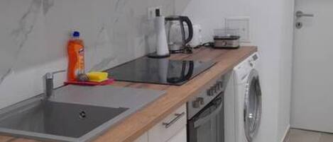 Een microgolfoven, een oven, een kookplaat, een waterkoker