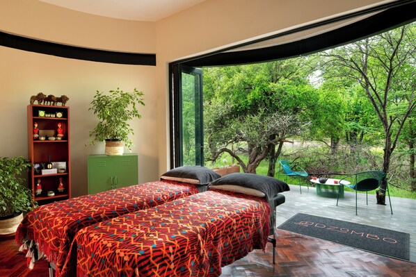 A bedroom with two beds, a green cabinet, a potted plant, and a view of the outdoors. - Dzombo Camp (Pilanesberg National Park)