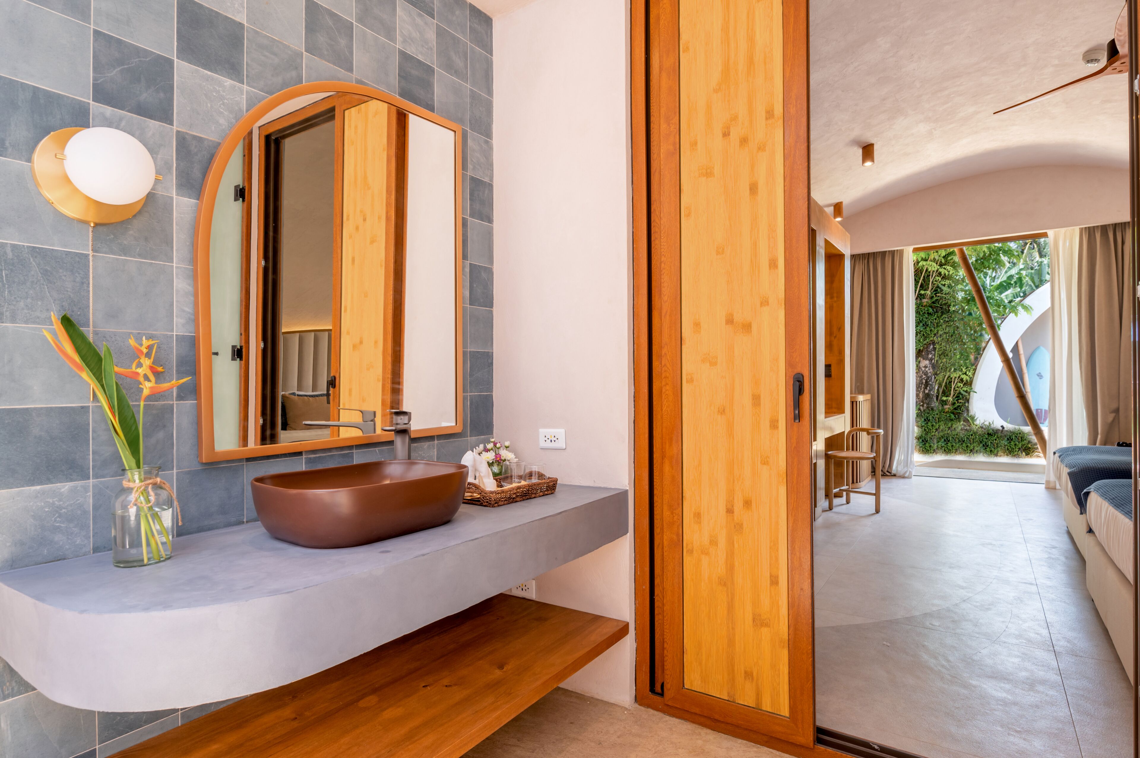 A modern bathroom with a large mirror, a wooden vanity, and a large bowl sink.