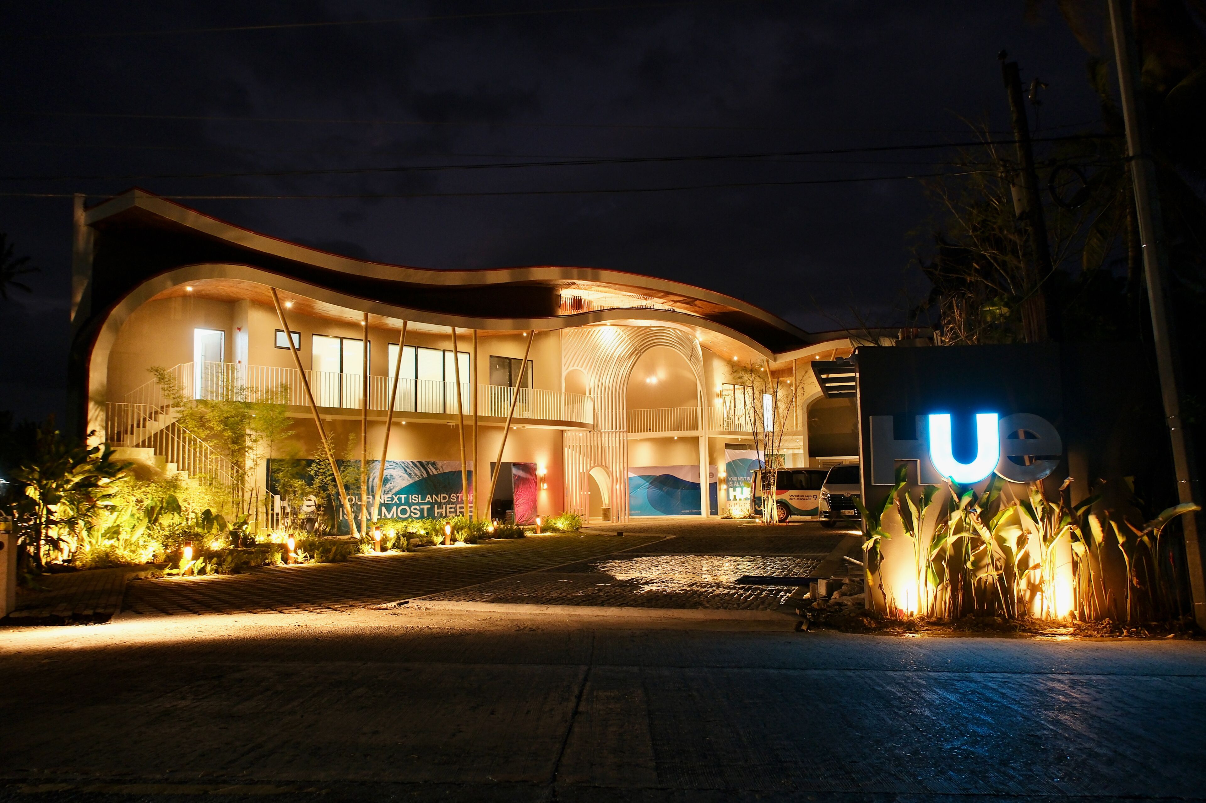 A modern building with a curved facade, large windows, and a prominent 'U' sign.