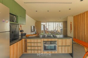A modern kitchen with wooden cabinets, a built-in oven, and a microwave.