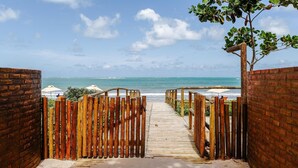 A wooden pathway leading to a beach with a view of the ocean.
