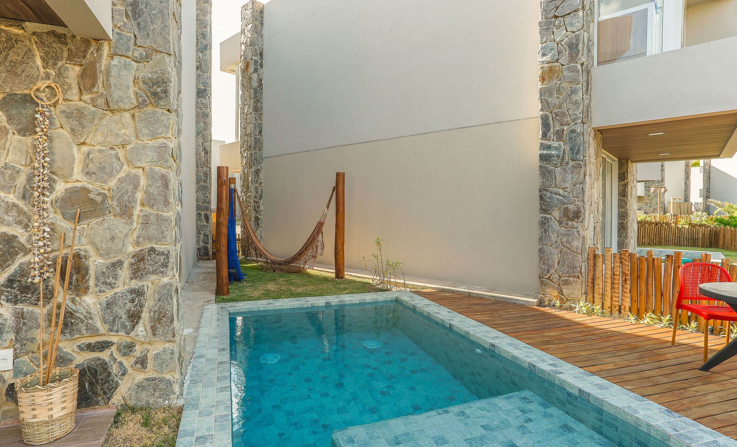 A swimming pool with stone walls and a wooden deck.