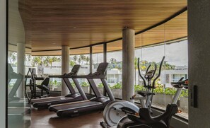A gym with treadmills, elliptical machines, and a rowing machine, featuring large windows and a wooden ceiling. - House With Pool at Praia do Marceneiro Nluh0008 (Passo de Camaragibe)