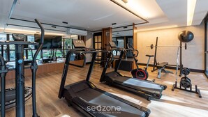Un gimnasio moderno con cintas de correr, máquinas de pesas y un muro de espejos.