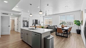 A modern kitchen with a central island, built-in appliances, and pendant lighting.
