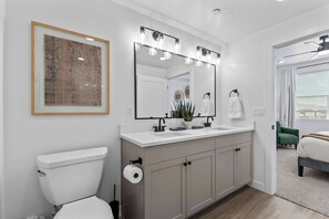 A modern bathroom with a toilet, sink, and mirror.