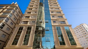 A high-rise building with a central glass facade, multiple balconies, and a modern architectural design. - Modern apt W/sea View in Porto Belo SC Mre801 (Porto Belo)