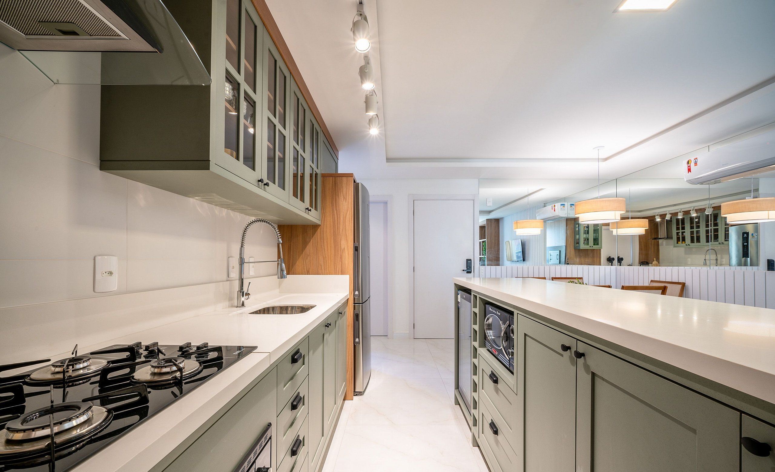 A modern kitchen with a central island, stainless steel appliances, and a large window.
