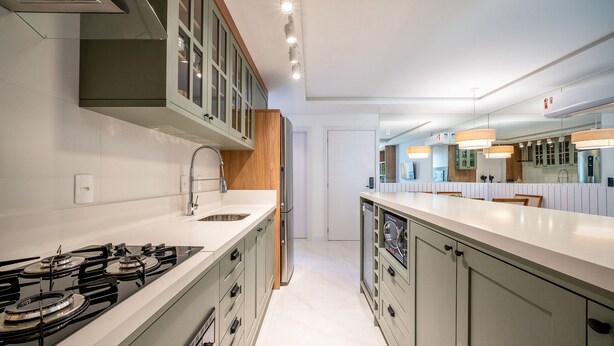 Una cocina moderna con una isla central, electrodomésticos de acero inoxidable y un amplio ventanal.