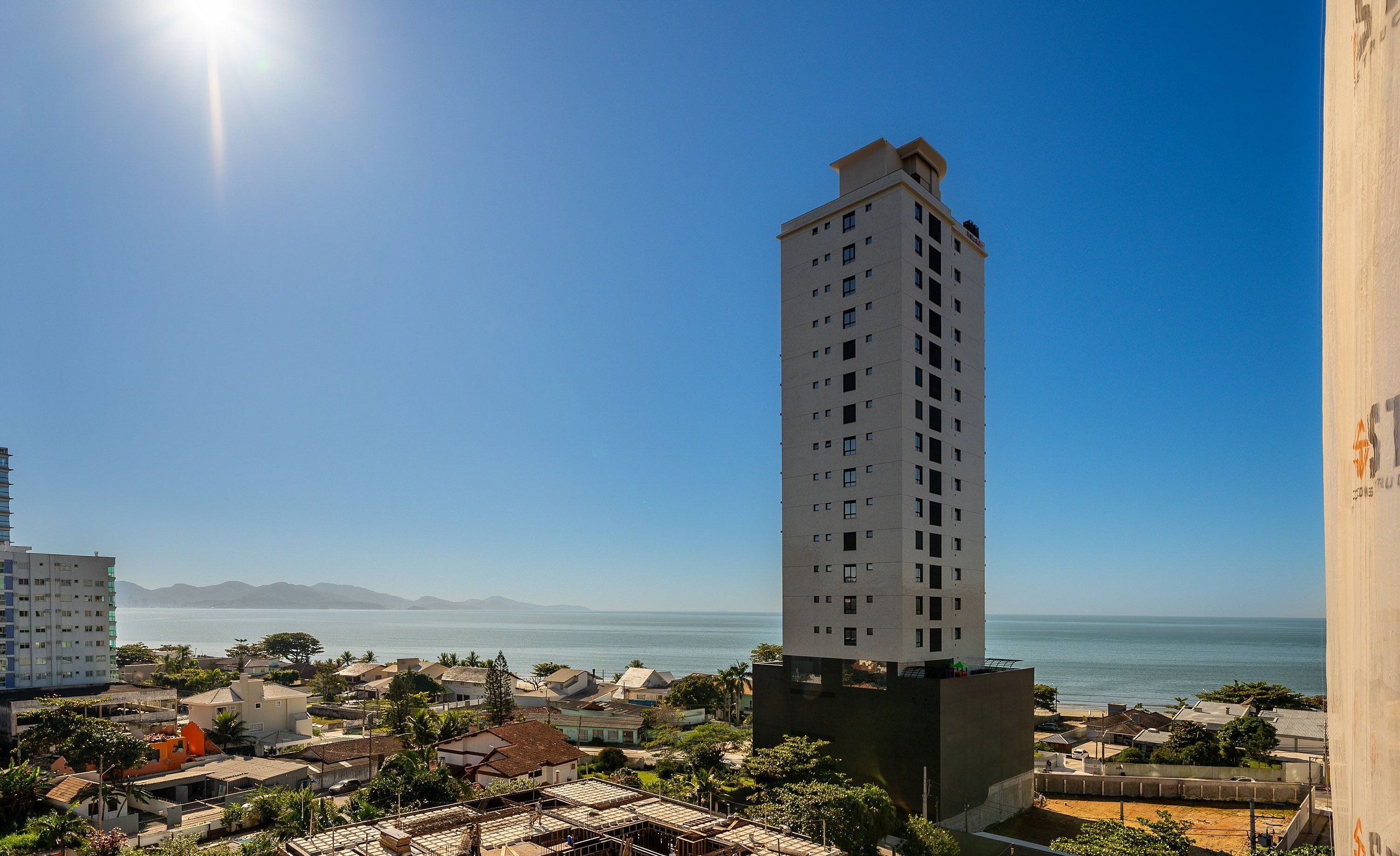 Ein Hochhaus mit Blick auf das Meer und die dahinterliegenden Berge.