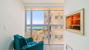 Eine moderne Wohnung mit einem großen Schiebeglasfenster, das auf einen Balkon mit Stadtblick führt.
