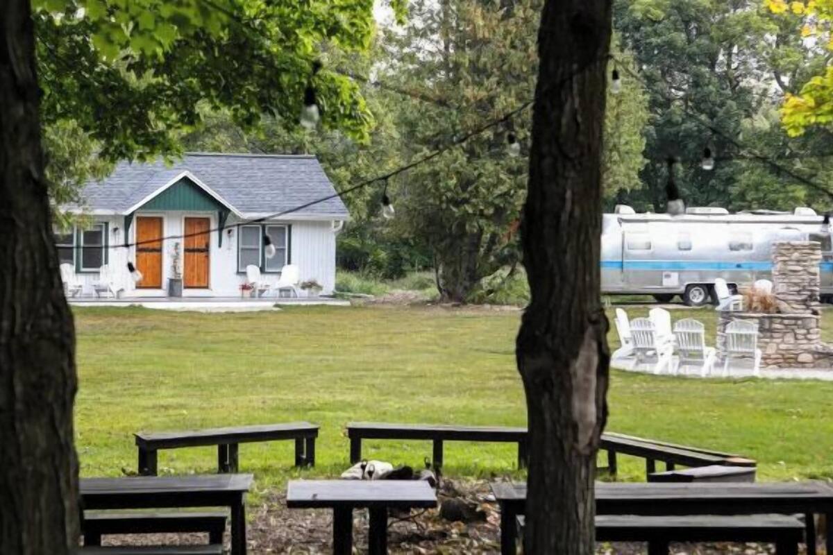 A house with a porch, a lawn, and picnic tables.