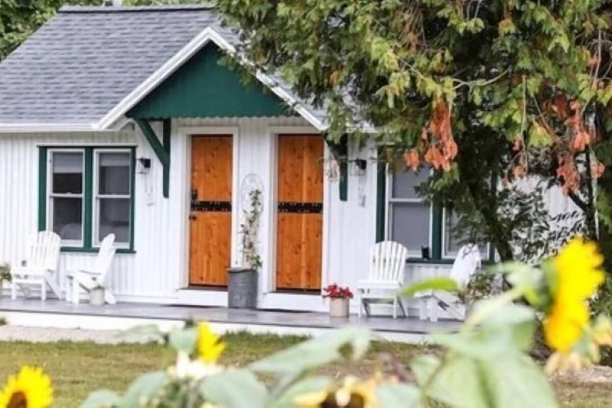 A small house with a porch, two doors, and a window.