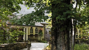 Un bâtiment en pierre avec un chemin en pierre menant à une porte en bois.