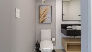 A modern bathroom with a toilet, sink, and mirror. - Penthouse 3 min From Jurere Beach - Mor0402 (Florianópolis)