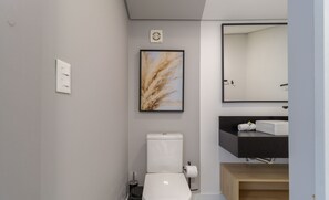 A modern bathroom with a toilet, sink, and mirror. - Penthouse 3 min From Jurere Beach - Mor0402 (Florianópolis)