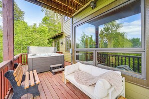 Une terrasse en bois avec un canapé blanc et un jacuzzi.