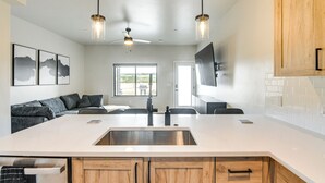 A modern kitchen with a large island, wooden cabinets, and pendant lighting. - Granby Ranch Escape: Shuttle to the Slopes! (Granby)