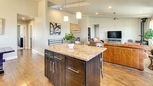 A spacious living area with a large dark wood cabinet, a granite countertop, and a brown leather sofa. - Panoramic Views: Spacious Home in Cedar City! (Cedar City)