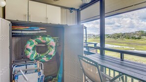 Ein Zimmer mit Blick auf ein Gewässer, eine Bank und ein Fenster mit Blick auf eine Wiese.