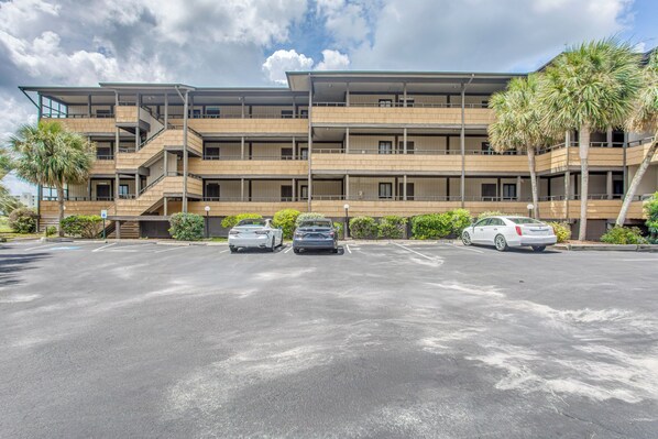 A multi-story building with a parking lot in front.