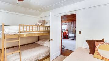 A bunk bed room with a door leading to a hallway.