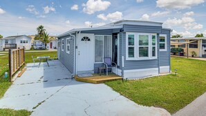 A small, single-story mobile home with a porch and a welcome mat. - 3 Mi to Ft Myers Beach: Coastal Home Near Leetran! (Fort Myers Beach)