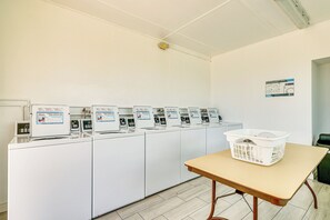 A laundry facility with multiple washing machines and a table with a basket. - 3 Mi to Ft Myers Beach: Coastal Home Near Leetran! (Fort Myers Beach)