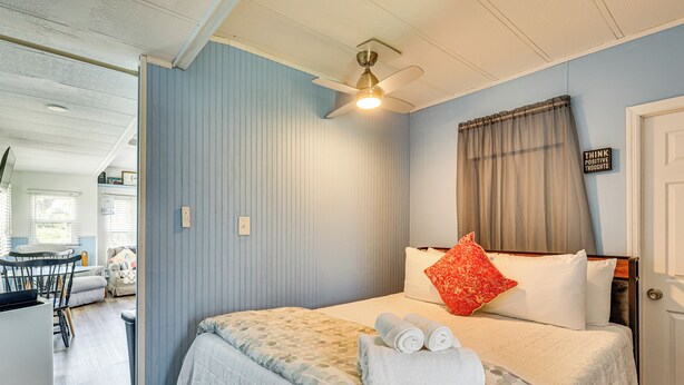 A bedroom with a bed, a ceiling fan, a window with curtains, and a sign on the wall. - 3 Mi to Ft Myers Beach: Coastal Home Near Leetran! (Fort Myers Beach)