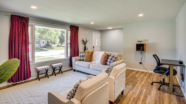A modern living room with a sofa, a coffee table, and a desk with a chair.