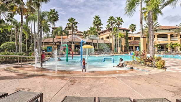 A resort pool area with palm trees, a water play structure, and lounge chairs. - Poolside Oasis: 7 Mi to Disney & Universal (Orlando)