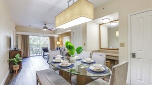 A dining area with a glass table, chairs, and a ceiling fan. - Poolside Oasis: 7 Mi to Disney & Universal (Orlando)