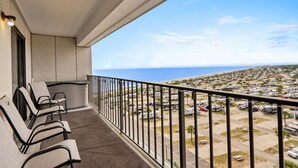 Un balcon avec coin salon extérieur, une vue sur la mer et un parking pour camping-cars.