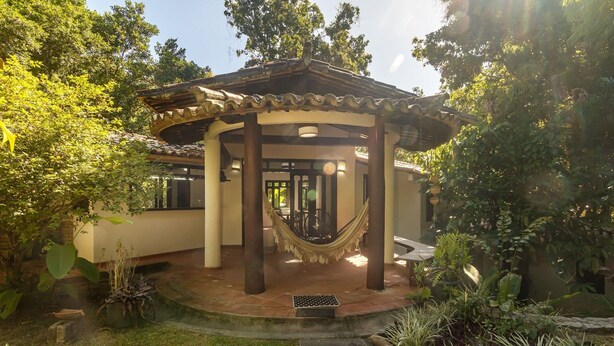 A gazebo with a tiled roof, surrounded by lush greenery and a small garden area. - House w/ 3 Suites 400m From Mucuge Beach Mcg0006 (Porto Seguro)
