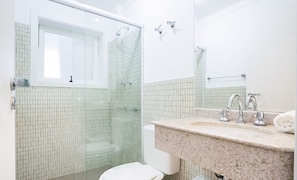 A modern bathroom with a glass shower enclosure, a white toilet, and a granite countertop with a sink and mirror. - Great apt for Families in Campos do Jordao Lvr010 (Campos do Jordão)