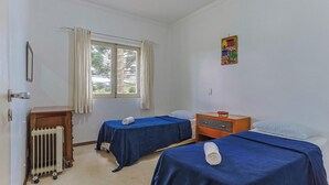 A room with two beds, a radiator, a window with curtains, and a small table. - Apart w Beautiful View in Campos do Jordao Lvr0003 (Campos do Jordão)