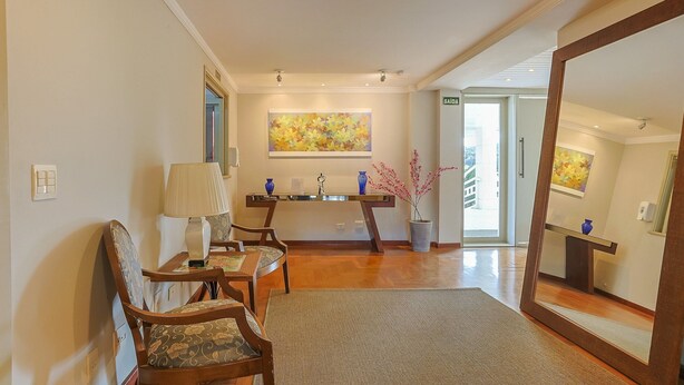 A hotel lobby with a reception desk, seating area, and artwork on the walls. - Apart w Beautiful View in Campos do Jordao Lvr0003 (Campos do Jordão)